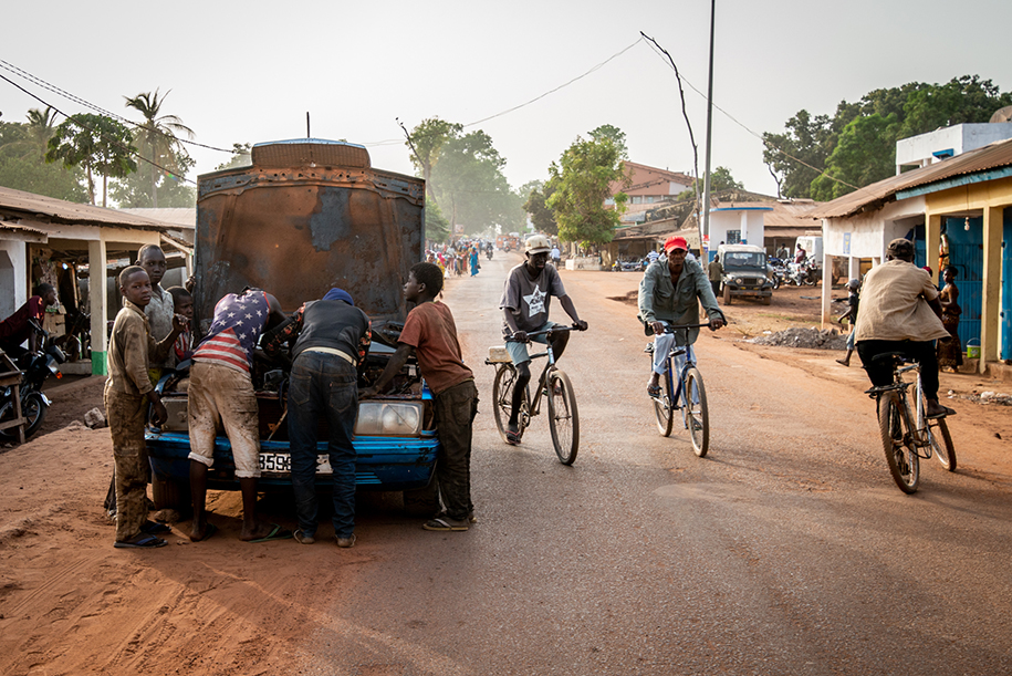 Car mechanics working on a car in the streets of Gabu, Guinee Bissau. Ellis work Photography